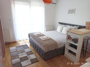 a small bedroom with a bed and a table at Studio Apartman TIM in Doboj