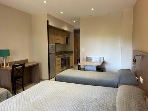 a small room with two beds and a kitchen at Hotel Corsica - Porto Corse in Porto Ota +69 photos