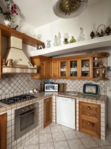 una cucina con armadietti in legno ed elettrodomestici bianchi di Casa Talento a Ponza
