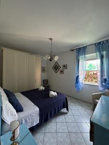 um quarto com uma cama azul e uma janela em Casa Talento em Ponza