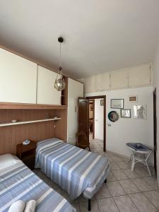 1 dormitorio con 2 camas y mesa. en Casa Talento, en Ponza