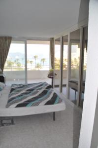 FeWo Mallorca-ideal - Mercedes في كالا مييور: غرفة نوم مع سرير وإطلالة على المحيط