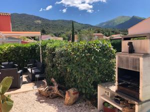 a garden with a fireplace and a bush at Belle Petite Villa climatisée dans résidence calme in Sorède +11 photos
