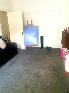 a living room with a painting on a stand next to a door at Ema apartment in London