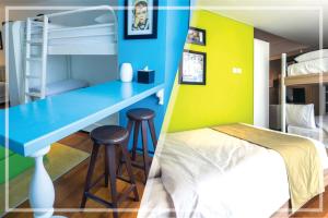 een slaapkamer met een blauw bureau en een stapelbed bij Yan's House Hotel in Kuta