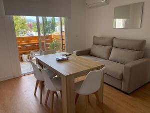 uma sala de estar com uma mesa e cadeiras e um sofá em Apartamento playa del Albir em Albir