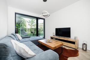 a living room with a couch and a tv at Garden Apartment in Banská Bystrica