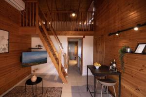 um quarto com uma escada e uma mesa e cadeiras em Ein Harod Country Lodge em ‘En H̱arod