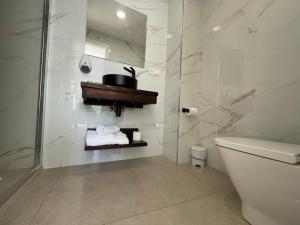 uma casa de banho branca com um WC e um chuveiro em Hostal montevideo em Nigrán