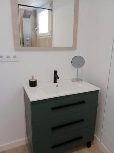 een badkamer met een groene dressoir met een spiegel bij Ático en el centro de Estella in Estella