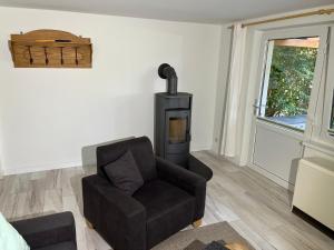 a living room with a chair and a stove at ''Zur alten Boddenfischerei'' Ferienwohnung Weitblick in Saal