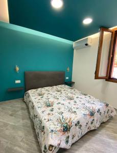 ein Schlafzimmer mit einem Bett in einem Zimmer mit blauen Wänden in der Unterkunft Suite GuestHouse a pochi passi dal mare in Sassari