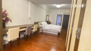 een slaapkamer met een tafel en stoelen en een bed bij 美達民宿 in Donggang