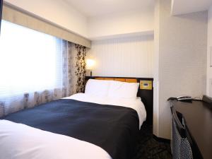 a hotel room with two beds and a window at APA Hotel Shizuoka-eki Kita in Shizuoka