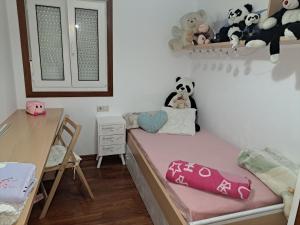 um pequeno quarto com uma cama com bichos de peluche na parede em Porto de Palmeira em San Pedro