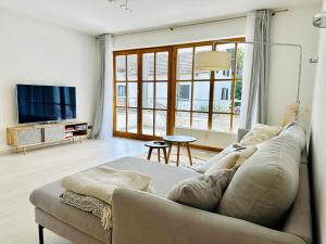 ein Wohnzimmer mit Sofa und Fernseher in der Unterkunft LIKE HOME, cozy apartment, 2 bedrooms, Netflix, 55" TV, balcony, parking, self-check-in in Penzberg