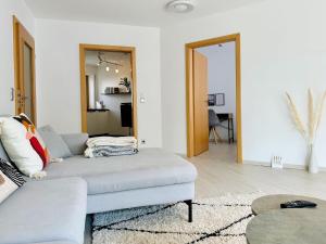 ein Wohnzimmer mit Sofa und Tisch in der Unterkunft LIKE HOME, cozy apartment, 2 bedrooms, Netflix, 55" TV, balcony, parking, self-check-in in Penzberg
