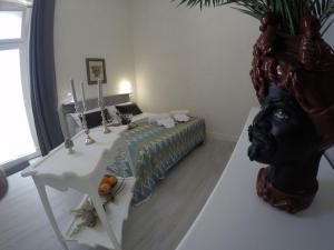 Un dormitorio con una cama con una mesa y una estatua en Borgata di Levante, en Siracusa