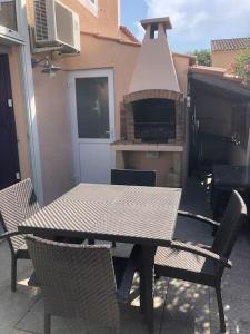 un tavolo e sedie su un patio con forno a legna di Pavillon 3 chambres avec véranda et climatisation. a Sorède Altre 28 foto