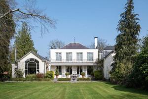 a large white house with a large yard at B&B Huis Spaas in Neerpelt