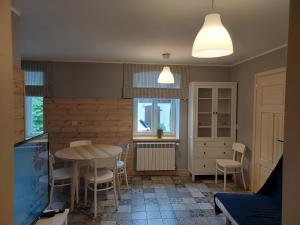 a dining room with a table and chairs and a tv at Apartamenty Święta Lipka in Święta Lipka