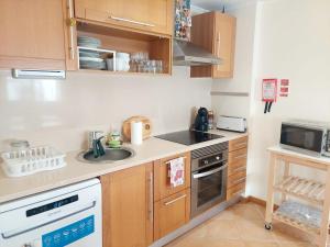 a small kitchen with a sink and a microwave at Casa Algarviana in São Bartolomeu de Messines