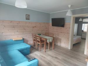 a living room with a blue couch and a table at Apartamenty Święta Lipka in Święta Lipka