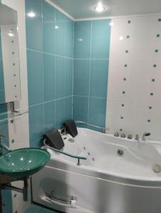 y baño con bañera y lavabo verde. en Astara Paradise Villa en Astara
