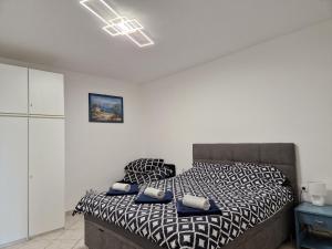 a bedroom with a bed with a black and white comforter at Apartman"Petra" in Krk