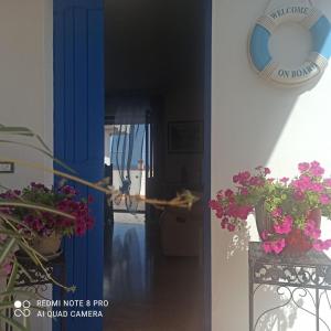a hallway with a blue door with flowers and a clock at HAIKU HOME in Cala Gonone