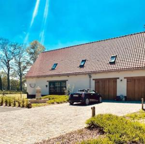 a car parked in front of a building at Prachtige vakantiewoning met weids uitzicht in Maldegem