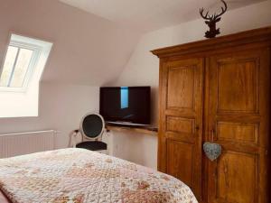 a bedroom with a bed and a dresser and a tv at Romantische vakantiewoning met weids uitzicht in Maldegem