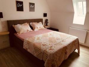 1 dormitorio con 1 cama con manta y almohadas en Romantische vakantiewoning met weids uitzicht, en Maldegem