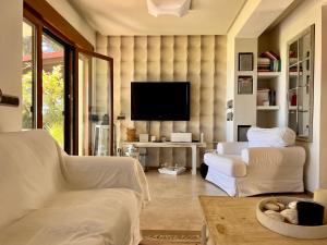 uma sala de estar com um sofá e uma televisão em Cute house by the sea em Kriopigi