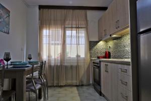 una cucina con tavolo, sedie e finestra di Διαμέρισμα κοντά στην παραλιακή a Alexandroupoli