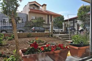 a garden with flowers in pots in front of a house at Διαμέρισμα κοντά στην παραλιακή in Alexandroupoli