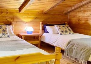 a bedroom with two beds in a log cabin at Baita Nord in Linguaglossa