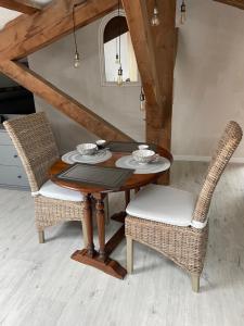 a wooden table with two chairs and a tableasteryasteryasteryasteryasteryasteryastery at LES VIEUX PLATANES in La Crau