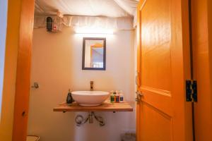La salle de bains est pourvue d'un lavabo sur une étagère en bois. dans l'établissement Moksham Himalayan Campsite Pangot, à Nainital