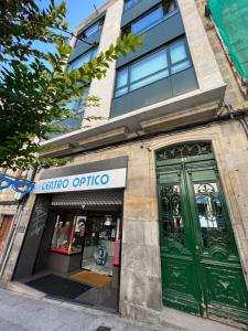 a store with green doors on a building at The Red Flat Vigo - Estudio Boutique - Centro Ciudad in Vigo