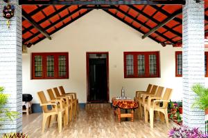 a patio with chairs and a table in front of a house at Hazel Retreat - Full Home & Coffee Estate in Chikmagalūr