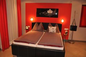 a bedroom with a large bed with a red wall at Appartementhaus Grill in Strobl +55 photos