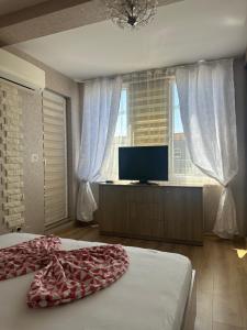 a bedroom with a bed and a flat screen tv at Abel Apartment in Pomorie