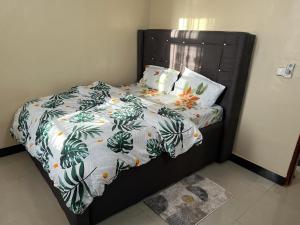 a bedroom with a bed with a black headboard at Mima's Apartment in Dar es Salaam