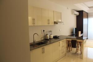 uma cozinha com armários brancos e um lavatório em Ocean Breeze Sea View Apartments em Negombo