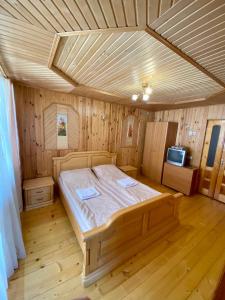 um quarto com uma cama num quarto de madeira em Zyma_Lito Guest House em Yaremche