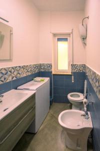 a bathroom with a sink and a toilet and a window at La Casa di Antonella in Agrigento