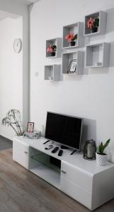a living room with a tv on a white table at Apartmani Bubamara Leskovac in Leskovac