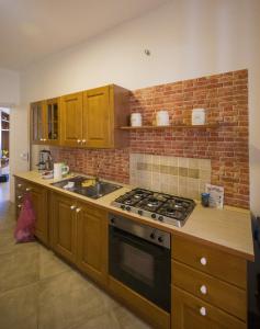una cucina con piano cottura e muro di mattoni di La Casa di Antonella a Agrigento