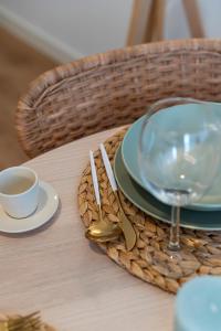 a table with a plate and a glass of wine at Chalet Marias - Parede beach apartments in Parede